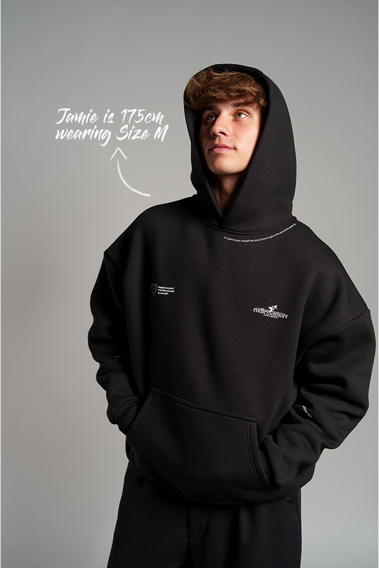 Schwarzer Hoodie mit weißen Schriftzügen auf Brust und Kragen sowie kleinem „endlessamore“-Logo; Kapuze aufgesetzt, Kängurutasche sichtbar.