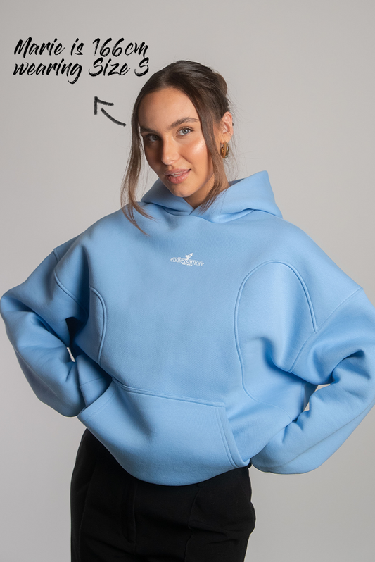 Hellblauer Oversized-Hoodie mit dezentem weißen Frontprint des Logos „endlessamore – created to spread love“ auf der Brust. Das Modell trägt Größe S bei 166 cm Körpergröße.
