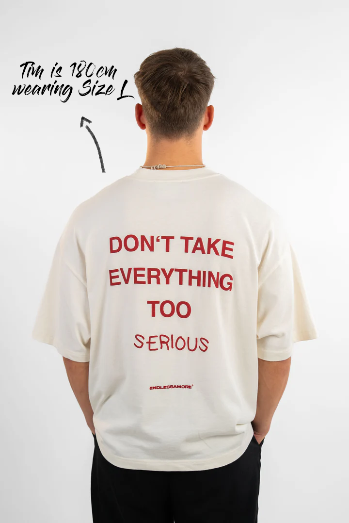 Rückansicht eines weißen T-Shirts mit rotem Rückendruck „DON’T TAKE EVERYTHING TOO SERIOUS“. Der Mann trägt Größe L bei 180 cm Körpergröße.