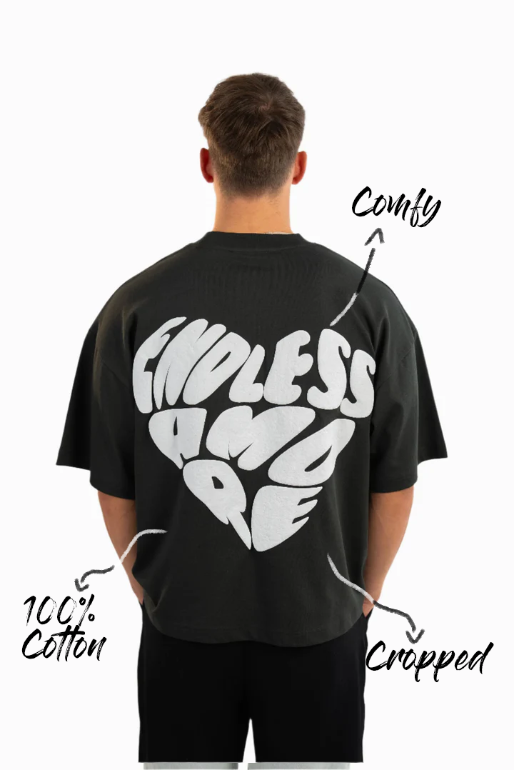 Rückansicht eines schwarzen Oversized-T-Shirts mit großflächigem Puffprint in Herzform, weißer Schriftzug „ENDLESS AMORE“. Markierungen: „100 % Cotton“, „Comfy“, „Cropped“.