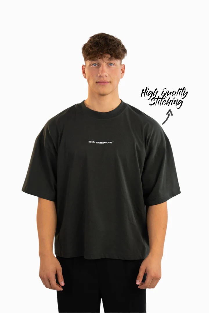 Schwarzes Oversized-T-Shirt mit kleinem weißen Frontprint „ENDLESSAMORE®“. Das Model steht frontal, Markierung zeigt auf „High Quality Stitching“.