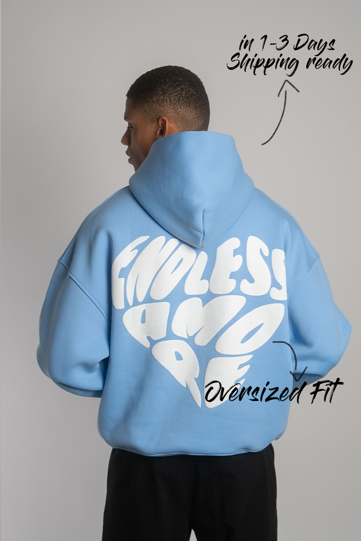 Rückansicht eines hellblauen Hoodies mit auffälligem weißen 3D-Puffprint „ENDLESS AMORE“ in dynamischer Anordnung. Weite Passform.