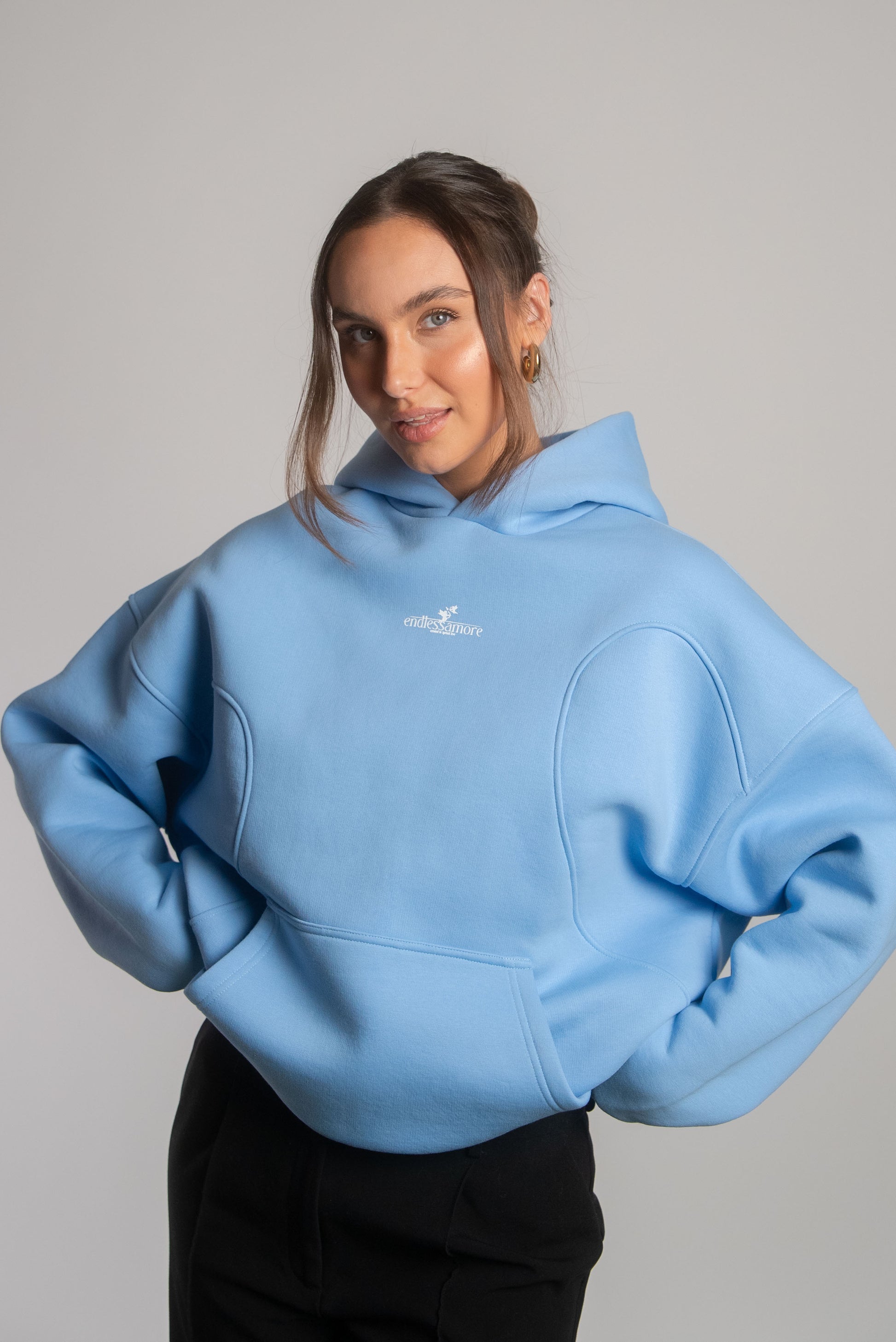 Hellblauer Oversized-Hoodie mit dezentem weißen Frontprint des Logos „endlessamore – created to spread love“ auf der Brust. Das Modell trägt Größe S bei 166 cm Körpergröße.