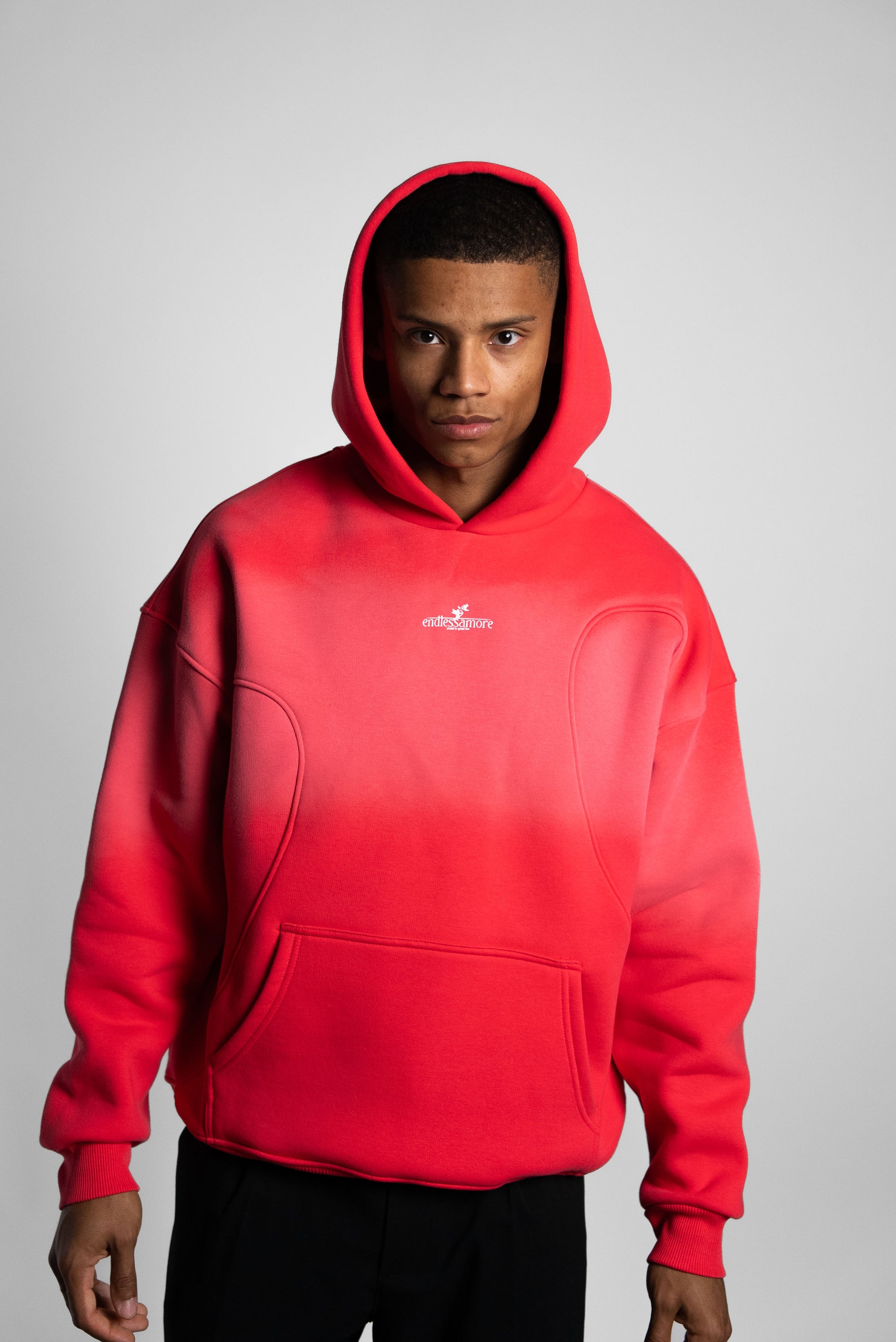 Oversized Hoodie in leuchtend rotem Farbverlauf mit Frontlogo „endlessamore“, getragen von einem Mann (185 cm) in Größe XL.